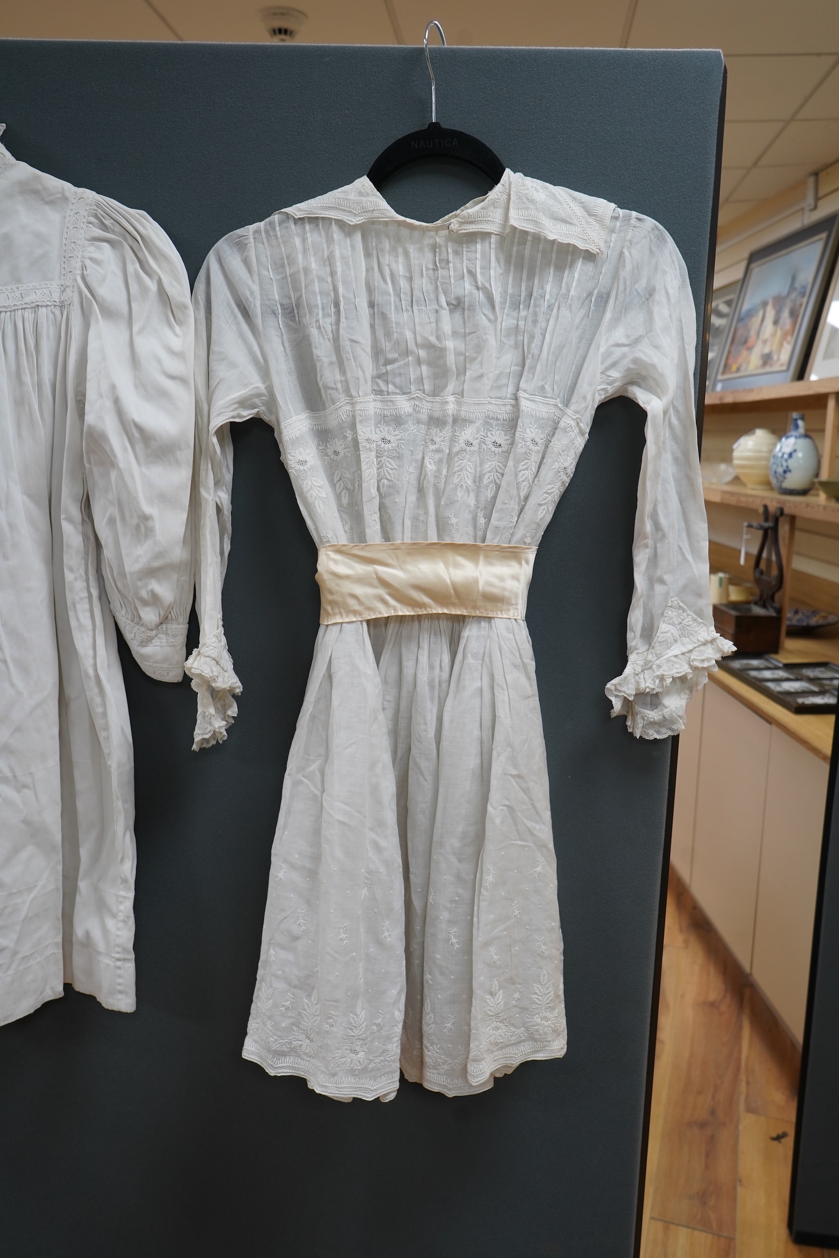 Two late 19th early 20th century girls summer dresses, one fine cotton with white worked collar cuffs and bodice, the other a cotton twill with anglaise collar large puff sleeves and gathered across the chest, lawn dress